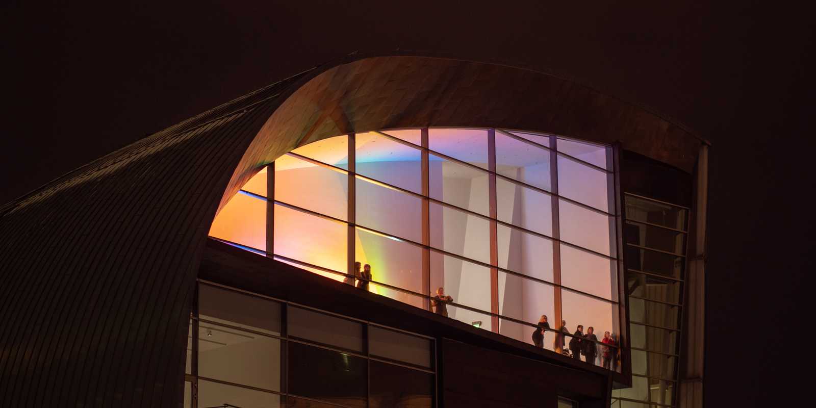 ihmisiä katsomassa parvekkeelta horisonttiin